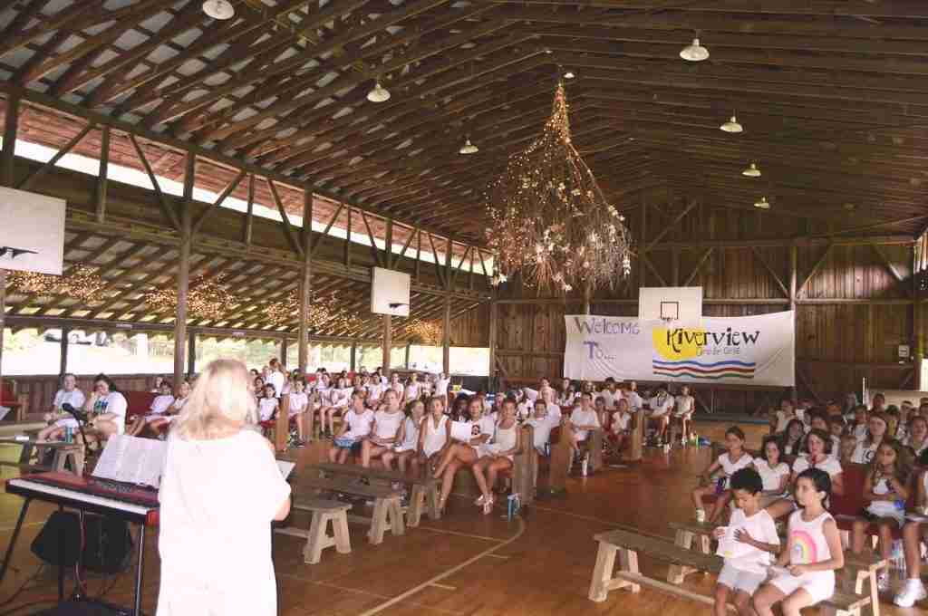 Campers dressed in white for Sunday worship in the open-air gym