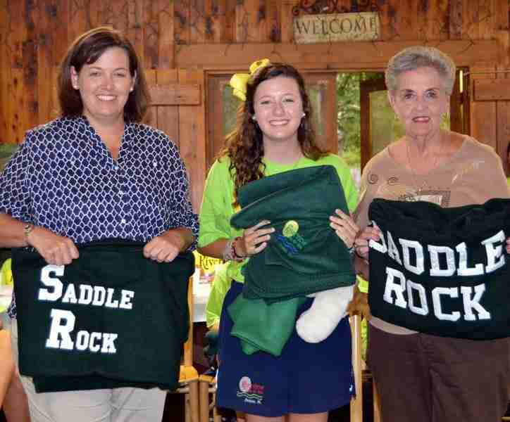 Three generations of campers holding their Saddle Rock camp blankets
