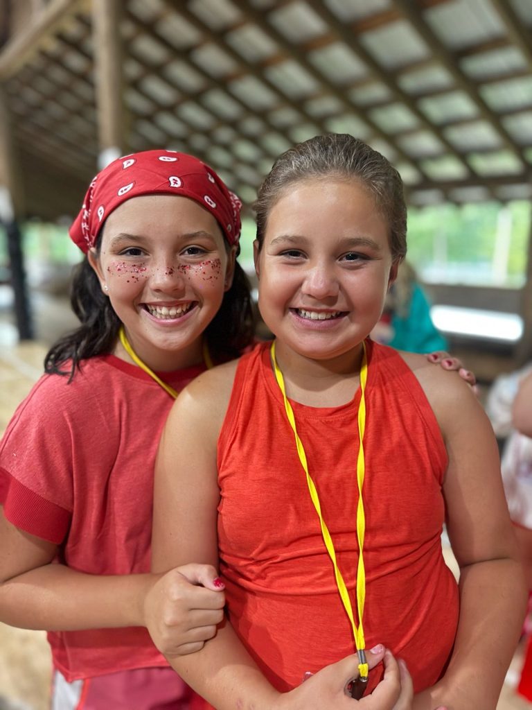 Two Riverview campers dressed in red for a team tradition