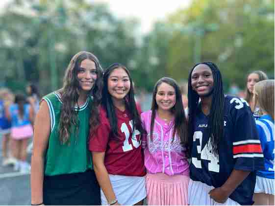Four smiling campers dressed up for a team spirit night
